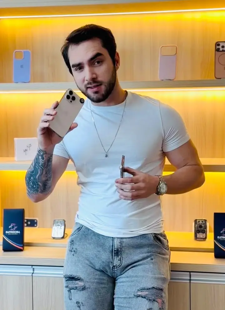 Christian, da EletroCell, mostrando um iPhone seminovo na loja